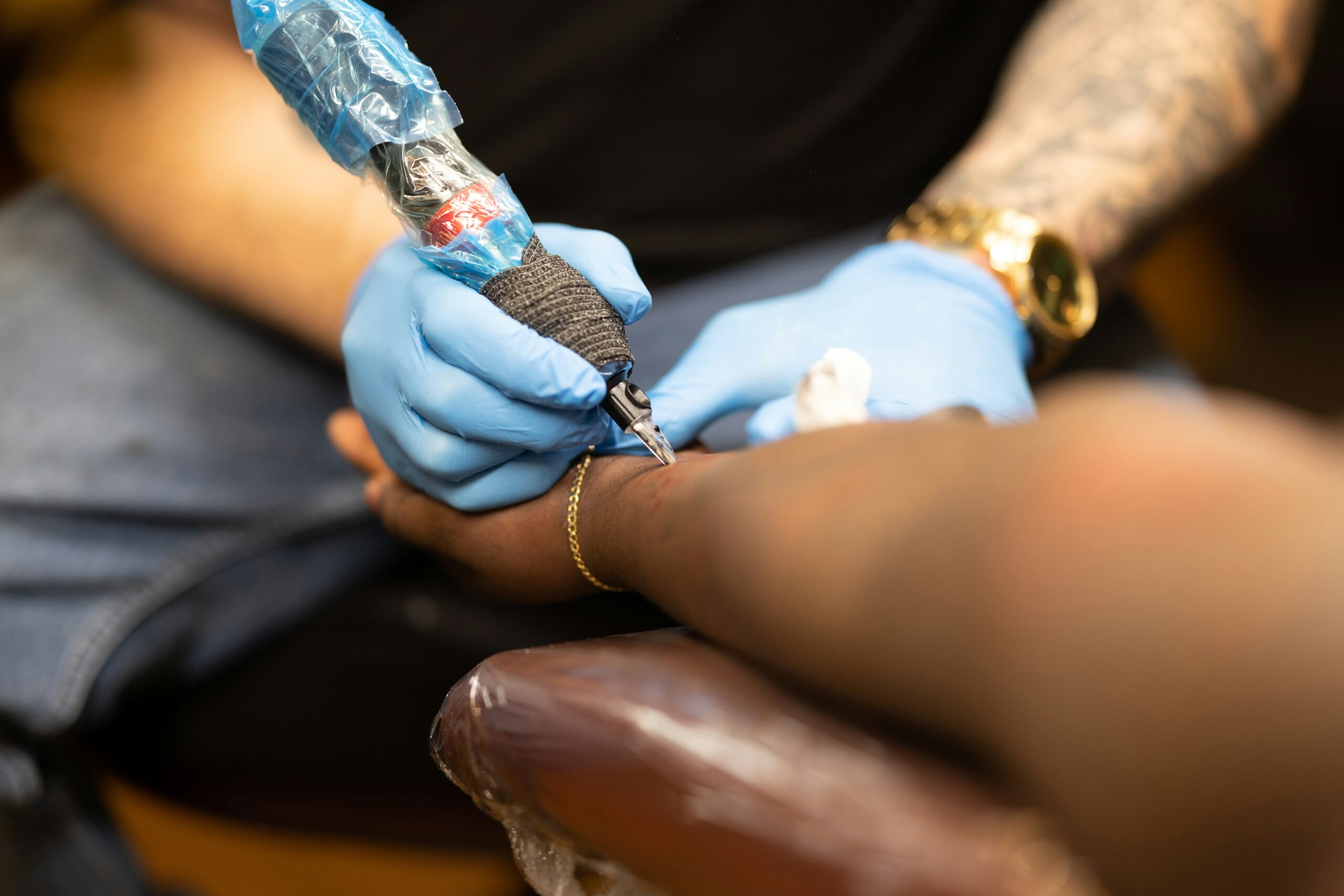 a person getting a tattoo on another person's arm